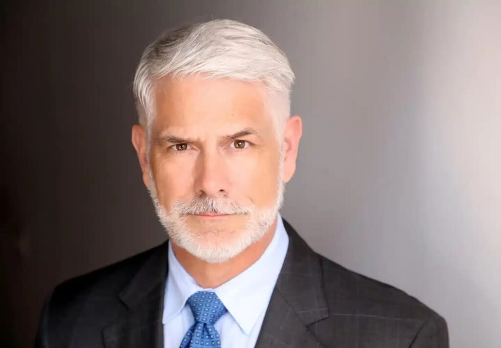 Corporate headshots portrait of a businessman in a dark pinstripe suit and blue patterned tie