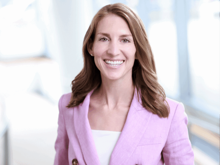 Professional woman wearing a pink blazer posing for corporate headshots in NYC